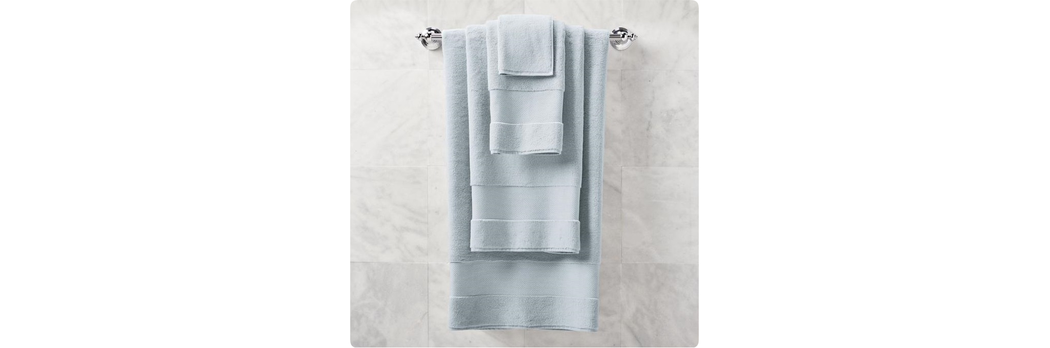 Multiple towels placed one on top of the other on a single towel bar